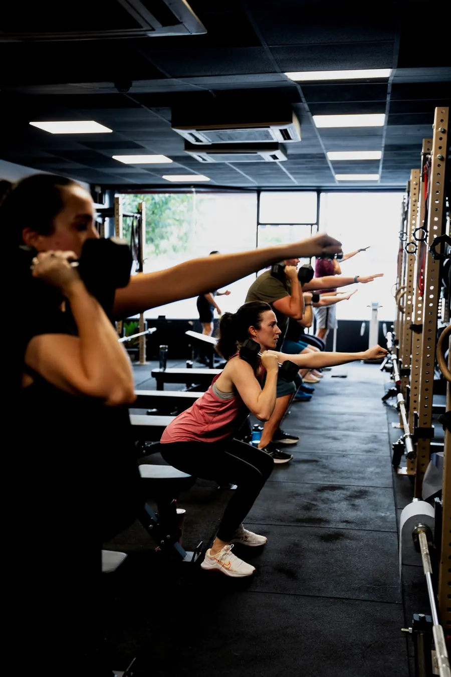 A small group training with kettlebells at Bo7 while a coach watches
